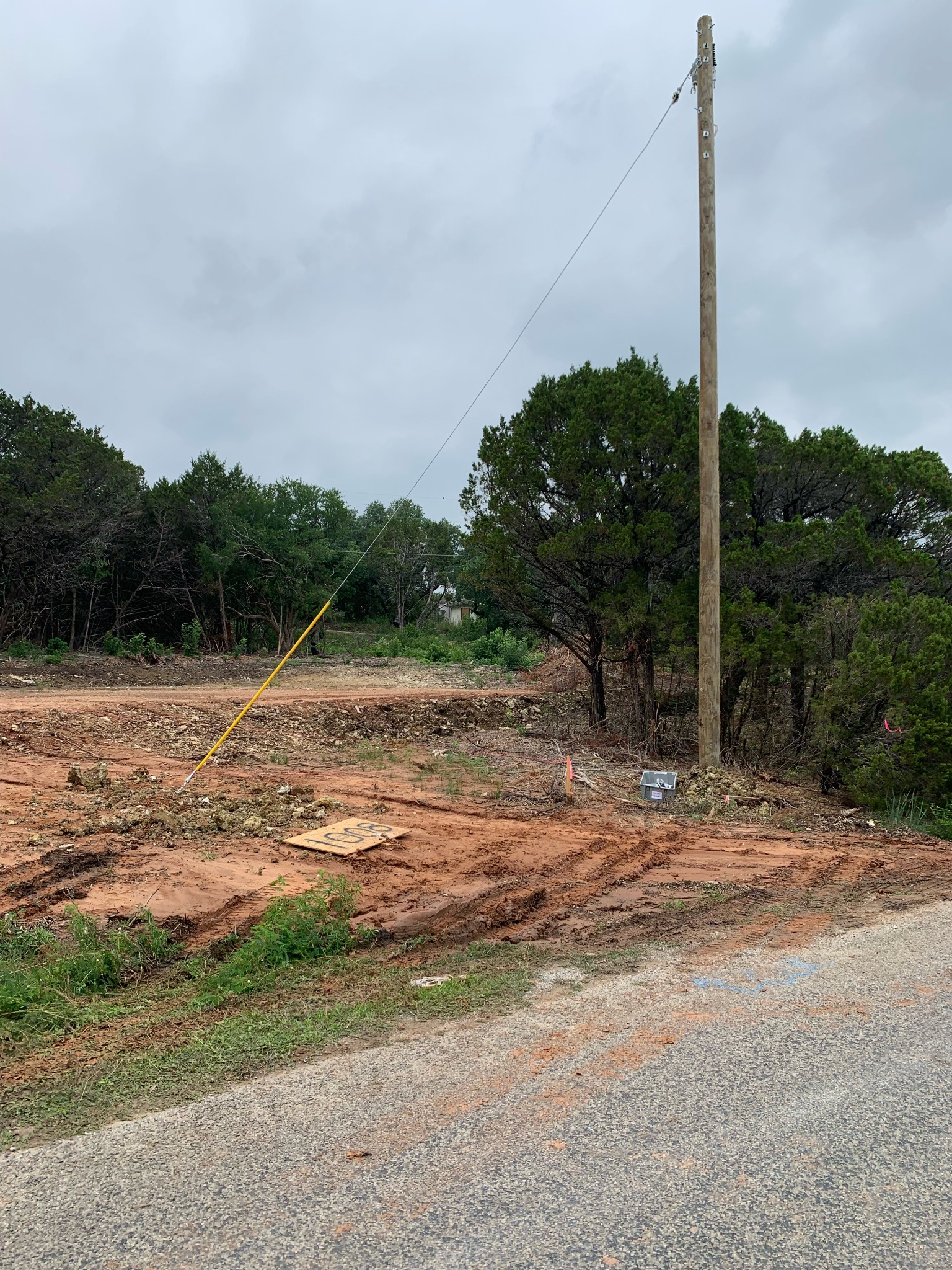 Cleared building site with utility pole and marked ground before home construction