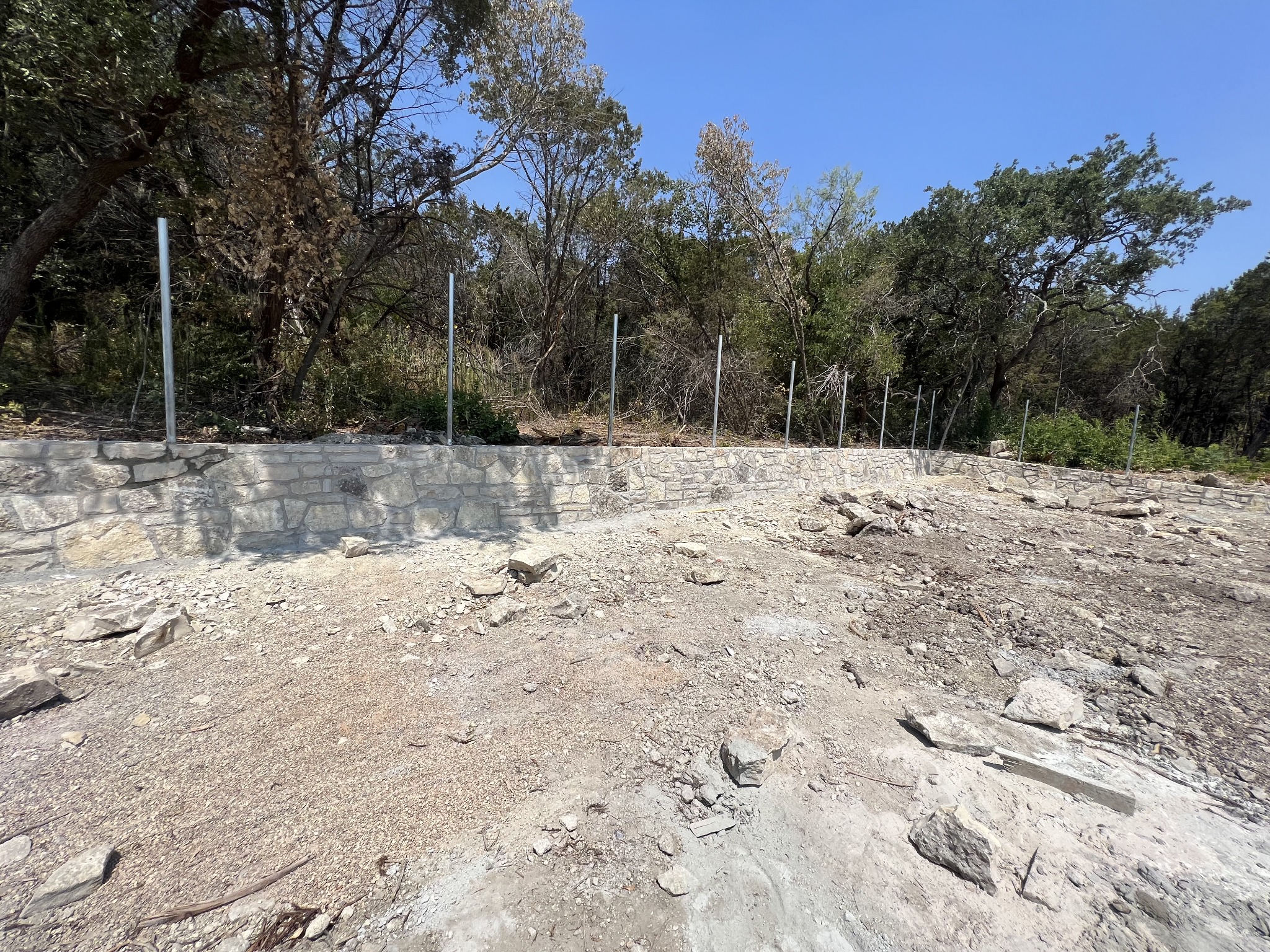 Stone retaining wall and prepared rocky ground at the home site
