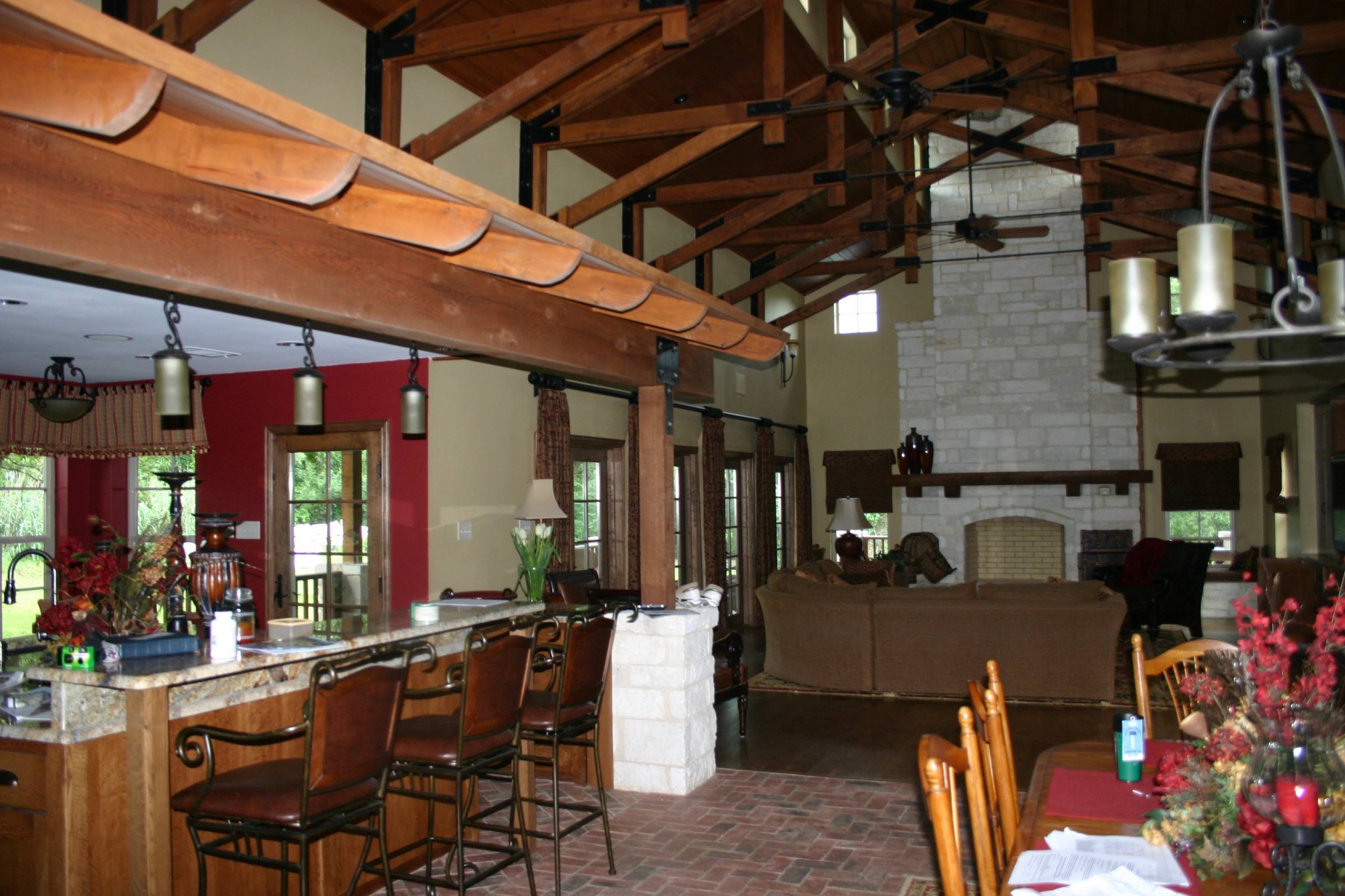 Finished remodeled living space with exposed timber beams, stone fireplace and kitchen bar